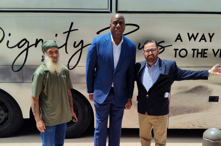 Standing in front of the Indian River County Dignity Bus, (left to right) Bus Driver Kyle, Magic Johnson and Anthony Zorbaugh. When touring the bus Johnson shared how great the Bus was and wished there were some in Los Angeles.