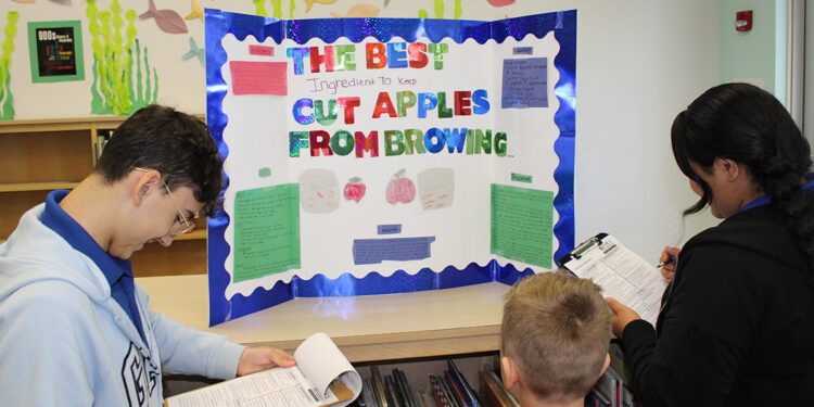 High school Navy JROTC Cadets judge elementary science fair in Sebastian, Florida.