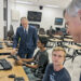 SRHS NJROTC Cadets Devon Desai (seated left) and Preston Kross (seated right) discuss the benefits of flight simulator software with Peter Petrelis (far right) and Jay Rinchak (far left).