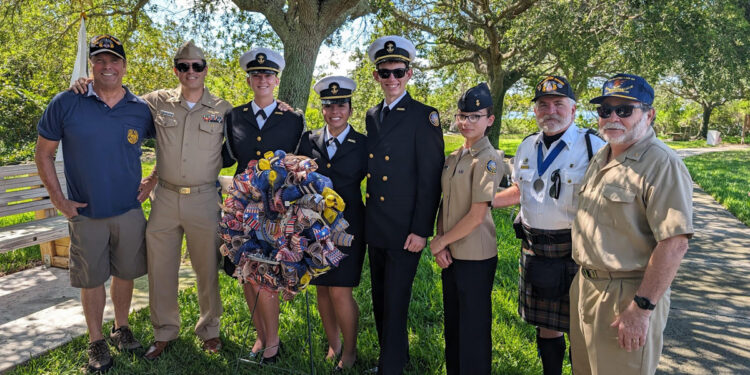 Ross Rowlinson (left) poses for a photo with Michael Hyde (second from right) and Sebastian River High School Navy JROTC personnel (from left to right) CDR (ret) Bissonnette, Cadet Bowen, Cadet Ortiz, Cadet Denning, Cadet Lopez.