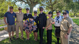 Ross Rowlinson (left) poses for a photo with Michael Hyde (second from right) and Sebastian River High School Navy JROTC personnel (from left to right) CDR (ret) Bissonnette, Cadet Bowen, Cadet Ortiz, Cadet Denning, Cadet Lopez.