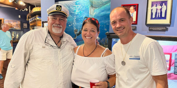 Vincent Trotta, left, Captain of the Mel Fisher’s Treasures company search and recovery vessel “DARE,” poses with Mel and Deo Fisher’s granddaughter Nichole Johanson and her husband James, in Sebastian, FL, during a Mel Fisher Days event. (Photo Credit: Jim Wilson)